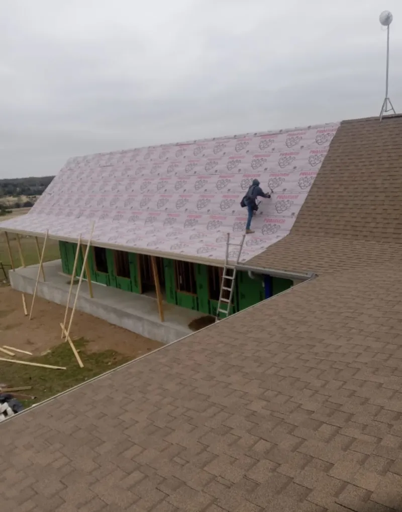 Worker preparing underlayment for a metal roof installation in Andalusia